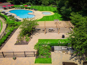 a garden with a swimming pool and a lawn with benches at Atlantic Pointe Apartments, New Jersey