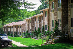 a row of brick apartment buildings with green grass and trees at Atlantic Pointe Apartments, Atlantic Highlands