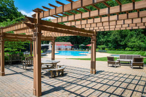 a pergola with tables and chairs near a swimming pool at Atlantic Pointe Apartments, Atlantic Highlands