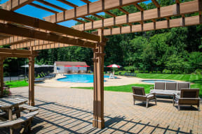 a pergola over a patio with chairs and a swimming pool at Atlantic Pointe Apartments, Atlantic Highlands, New Jersey