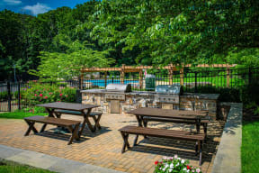 a patio with picnic tables and a pool in the background at Atlantic Pointe Apartments, Atlantic Highlands