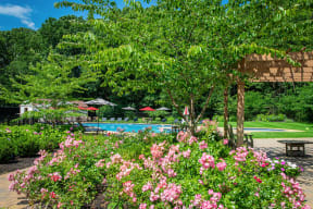 the pool is surrounded by flowers and trees at Atlantic Pointe Apartments, Atlantic Highlands