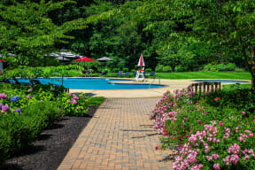 a swimming pool is surrounded by flowers and trees at Atlantic Pointe Apartments, Atlantic Highlands, New Jersey