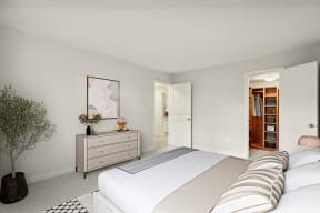 a white bedroom with a large bed and a dresser