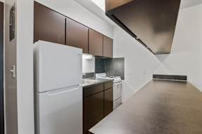 A white refrigerator is in a kitchen with brown cabinets.