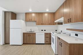 A modern kitchen with wooden cabinets and white appliances.