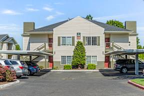 A large two-story building with a parking lot in front.
