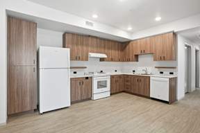 A modern kitchen with wooden cabinets and white appliances.