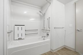 A white bathroom with a bathtub and a shower.