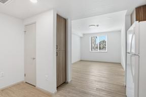 A white room with a wooden floor and a window.