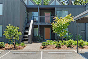 A modern house with a grey exterior and a wooden door.