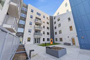 A courtyard with a sandbox and a building with balconies.