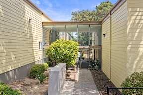 A modern house with a glass door and a small garden.