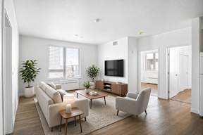 A living room with a couch, chair, and television.