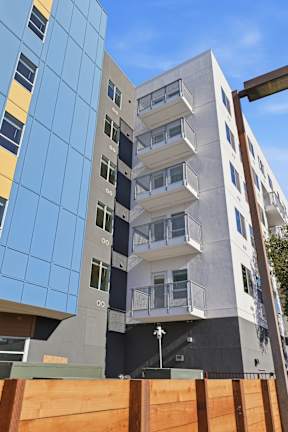 A modern building with a blue glass facade and a white concrete facade.