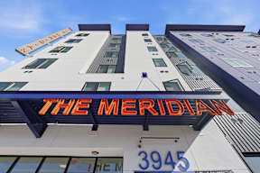 The Meridian building has a blue and orange sign on it.