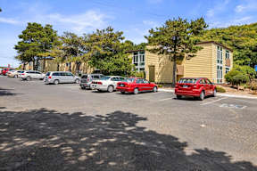 A parking lot with cars and a building in the background.