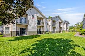 Apartment complex with green lawn in front.
