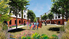 A group of people are standing in a garden in front of a building.