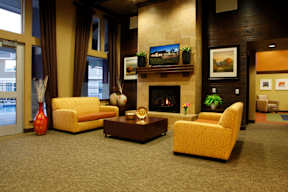 a large living room with yellow furniture and a fireplace