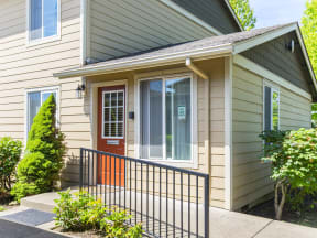 the front entrance to a house with a red door