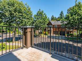 A metal fence with a gate is in front of a house.