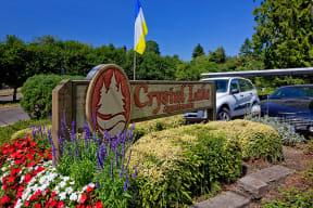 a sign for the cystic fibrosis association in front of a garden of flowers
