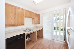 a kitchen with wooden cabinets and a sliding glass door