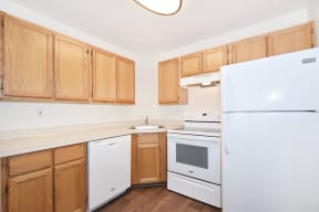 a kitchen with white appliances and wooden cabinets