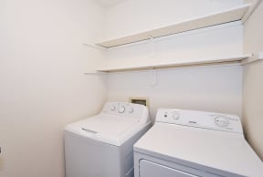 a washer and dryer in a room with a shelf over the washer