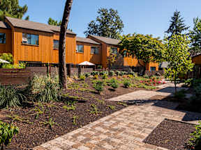 a courtyard with a path and houses in the background