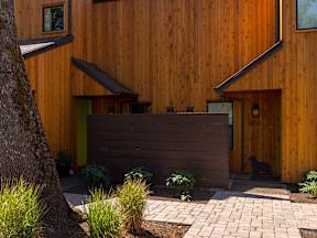 a brown privacy fence in front of a wooden house