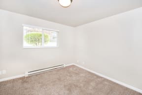an empty room with carpet and a window