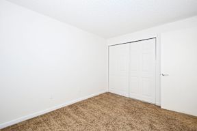 a bedroom with a door and carpeted floor