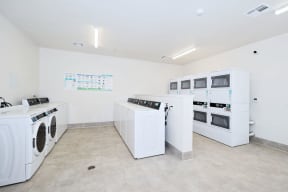 a laundry room with washers and dryers and white appliances