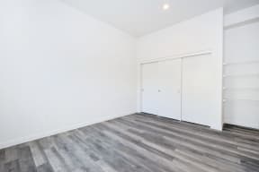 an empty room with white walls and wood floors