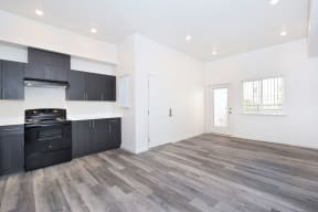 the kitchen and living room of a new home with black appliances and white walls