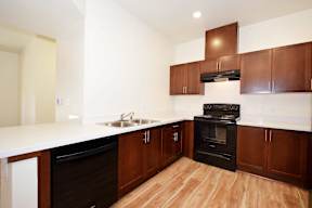A kitchen with wooden cabinets and a black oven.