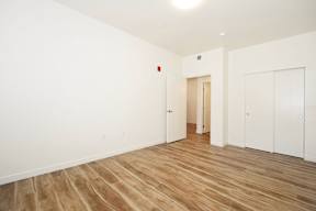A room with wooden flooring and white walls.