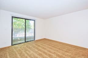 a bedroom with a large window and white walls