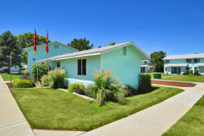 a blue house with two flags in front of it
