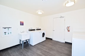 a white laundry room with a washing machine and a sink