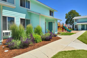 a blue house with a playground in front of it