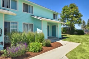a blue house with a sidewalk in front of it
