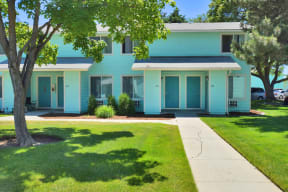 a blue house with a sidewalk in front of it