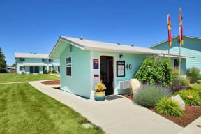the front of a blue building with a sidewalk in front of it