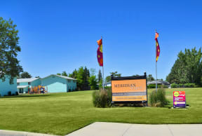 the sign for meridian elementary school with flags blowing in the wind