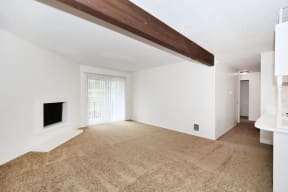 an empty living room with a fireplace and a window