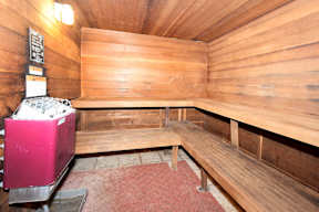 A wooden sauna with a bench and a heater.