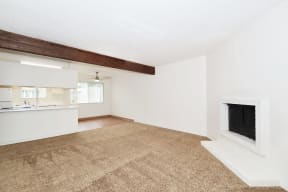a living room with white walls and a wood floor and a fireplace